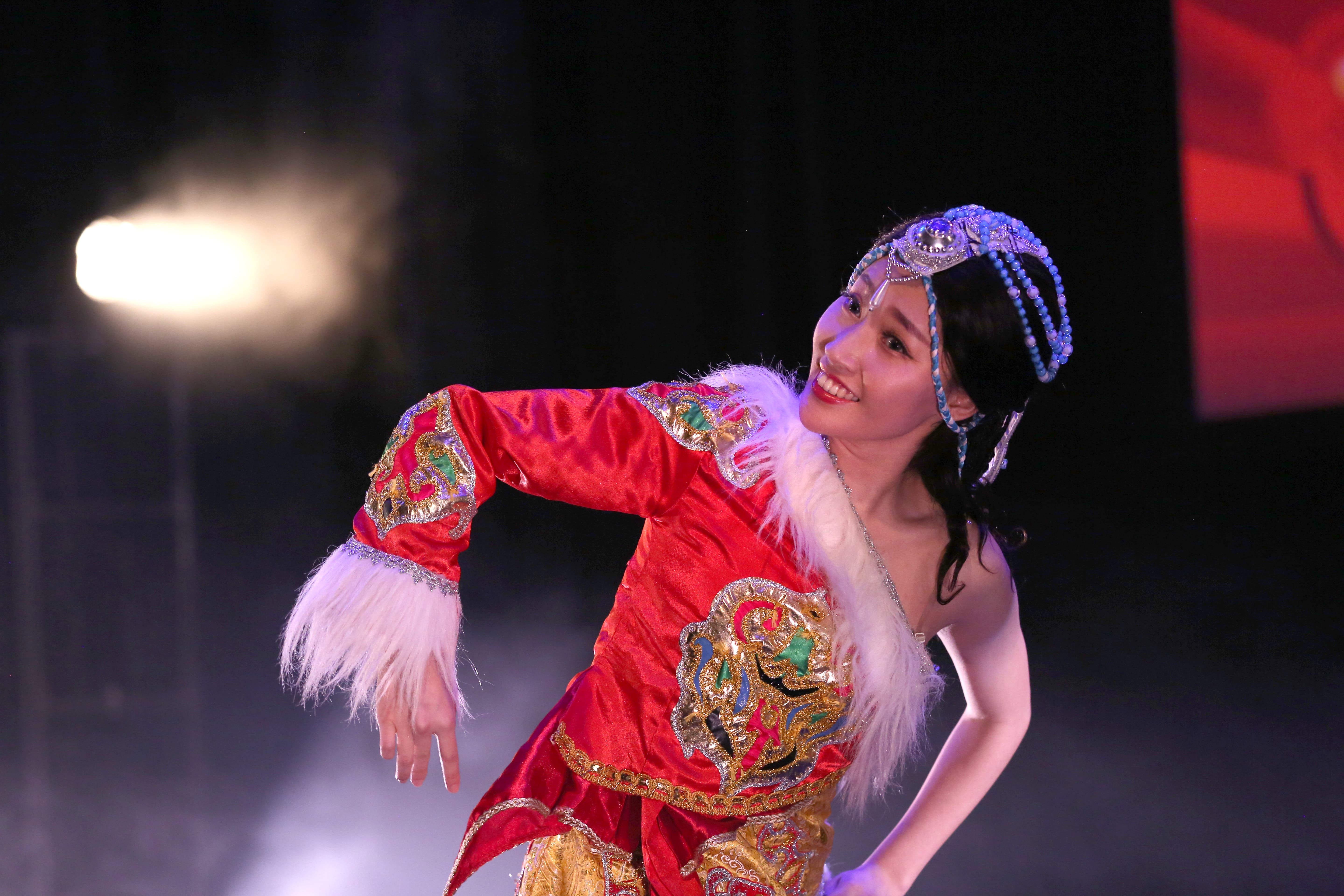 A woman wearing a traditional Chinese performance dress dances on stage.