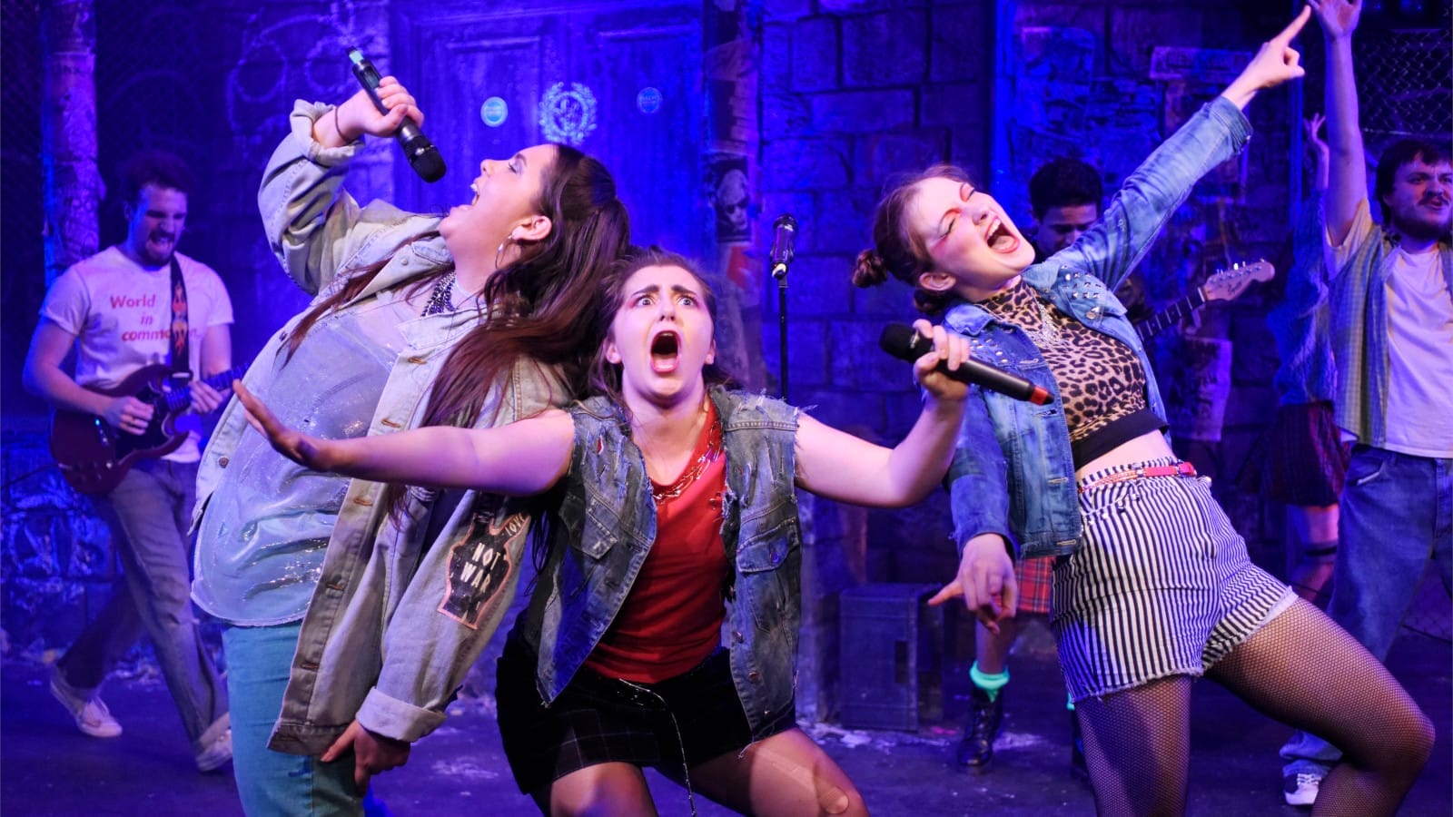 Three young women performing on stage